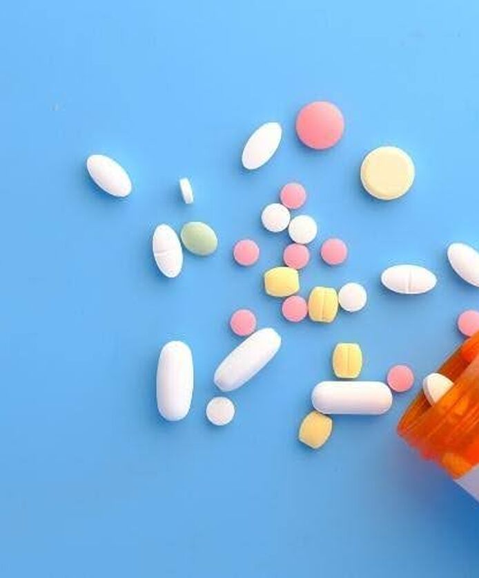 Weight loss pills spilled from prescription bottle.