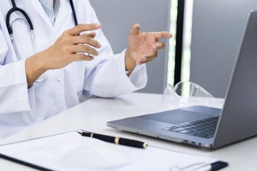 Doctor conducting an online medical consultation on a laptop.