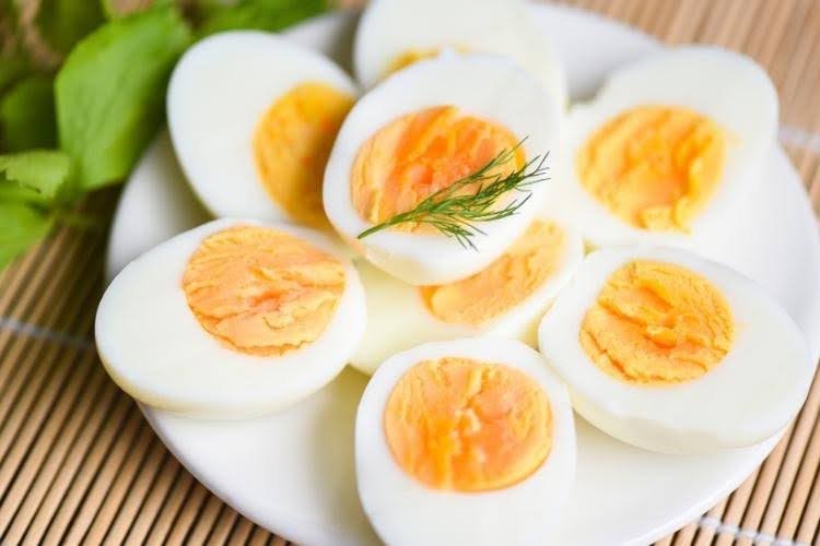 Boiled eggs sliced on plate high protein food.