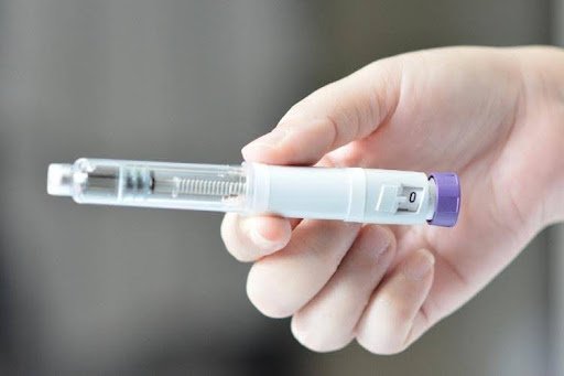 Person holding a weight loss injection pen