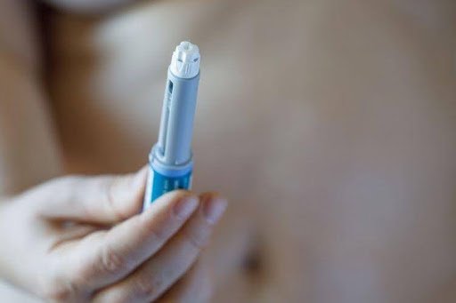 Person holding a Mounjaro injection pen.