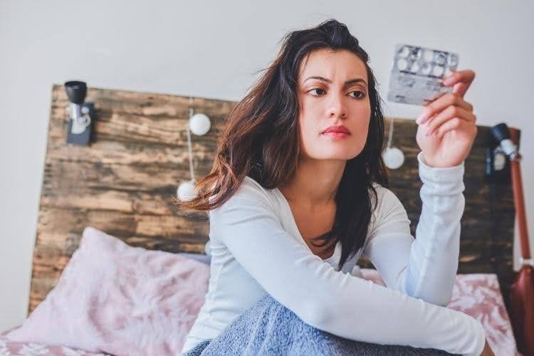 Woman reviewing medication information before taking Orlistat for weight loss.